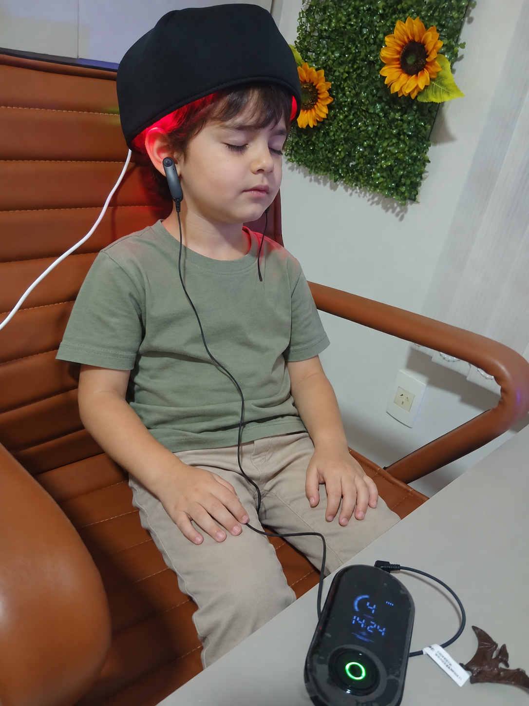Criança utilizando capacete de fotobiomodulação durante atendimento